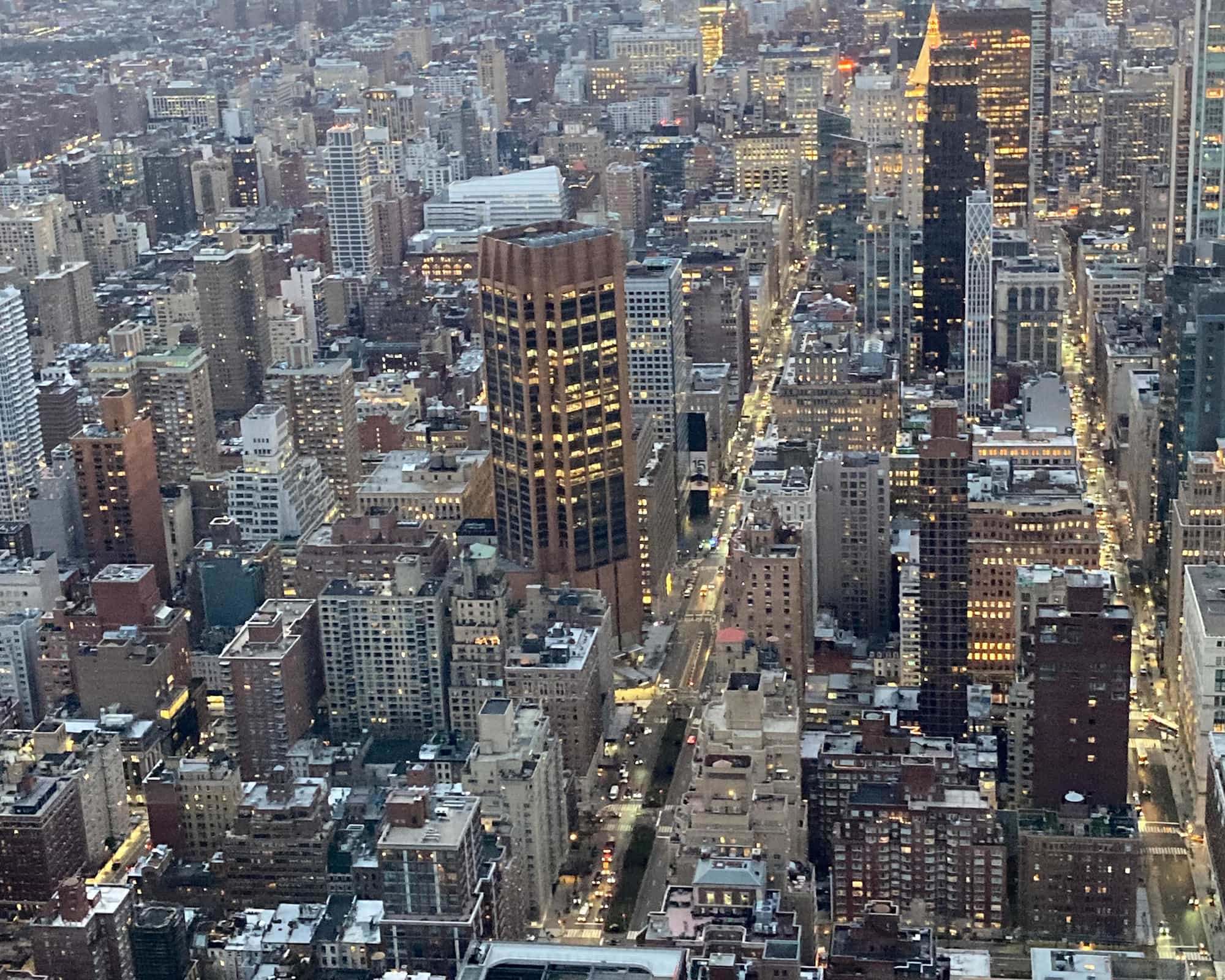 Aerial view of Manhattan at dusk, with lit office towers and streets